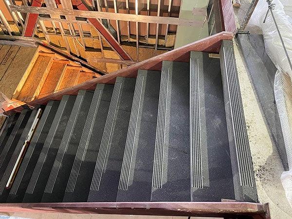 一层是混凝土楼梯，下一层是木楼梯