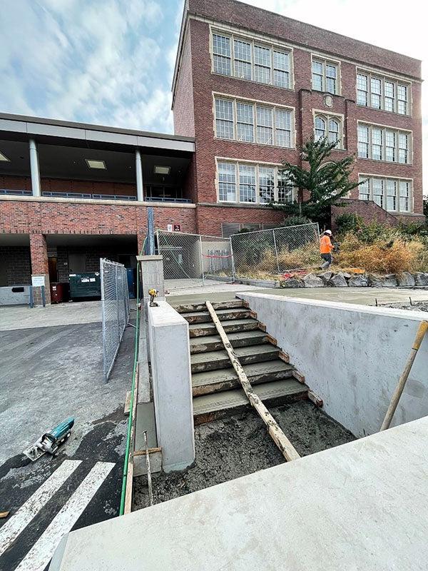 一栋砖砌建筑前的外部楼梯正在浇筑新混凝土