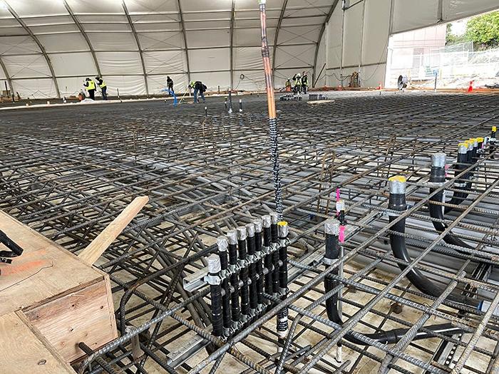 a vast spread of a rebar cage with workers adding more